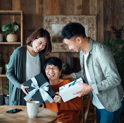 a senior mother receiving presents from her daughter and son at home