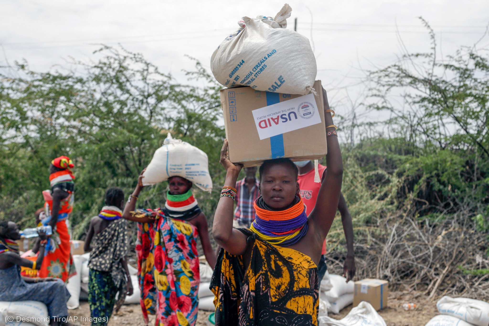 People carrying boxes and sacks with USAID labels on them (© Desmond Tiro/AP Images)